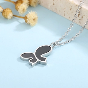 Detail of butterfly necklace showing black shell pendant on polished steel chain