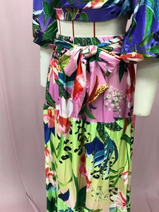Detalle de maxi vestido con estampado floral tropical, falda escalonada y lazo en cintura