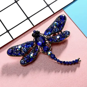 Detailed close-up of dragonfly brooch featuring blue crystals and rhinestones