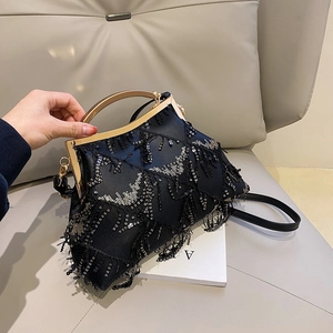 Detail of elegant black sequin evening bag with tassels and gold metal handle