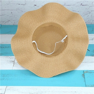 Detailed view of the wavy wide brim straw sun hat with an elastic windproof chin strap