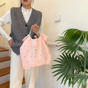 Detail of pink canvas tote bag featuring cute rabbit floral prints and checkered handles