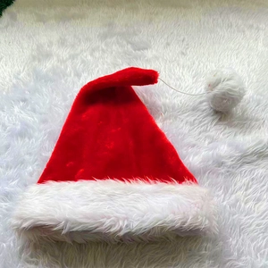 Detailed view of red plush Christmas hat with white faux fur trim on soft carpet