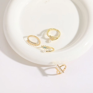 Set of four 14K gold plated rings with freshwater pearls, evil eye, and star motifs
