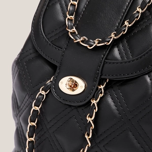 Mochila de cuero acolchado negro con cadenas doradas y cierre giratorio de mujer