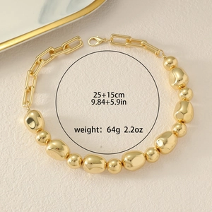 Detail of chunky gold chain necklace with irregular beads and lobster clasp closure