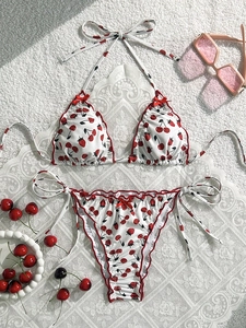 Flachbild von weißem Bikini mit Kirsch- und Erdbeerdruck und roten Rüschenkanten
