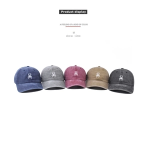 Row of washed cotton baseball caps with spider embroidery in five vintage colors