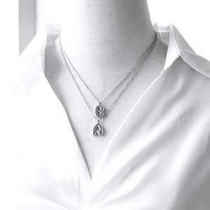 Silver double layer necklace with number 8 and letter A pendants on white shirt