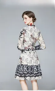 Détail d'une robe en mousseline fleurie avec col montant et bordure en dentelle noire au bas
