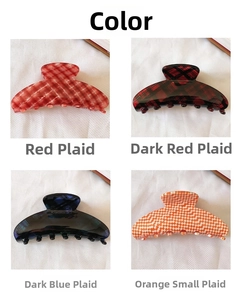 Detail view of four French style checkered acetate hair claws in red and blue patterns
