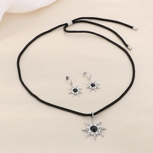 Parure bijoux en acier titane avec pierre noire sur fond de soie blanche