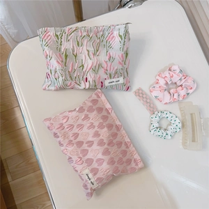 Detail of pink heart canvas makeup bag with floral scrunchies and matte hair claw set