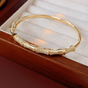Detailed shot of a gold-plated bamboo joint bangle with cubic zirconia on a velvet tray