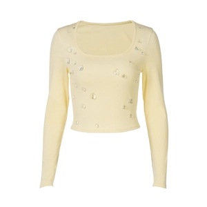 Dettaglio del crop top giallo a coste con decorazioni a goccia di cristallo e scollo a U