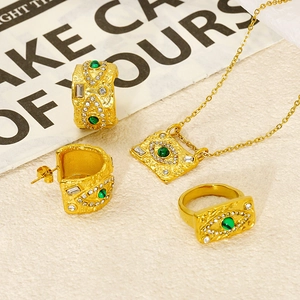 Detail view of 18K gold jewelry set with malachite eye motif on textured paper