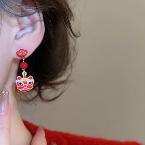 Close-up of Chinese New Year lion dance drop earrings with red enamel and RICH text