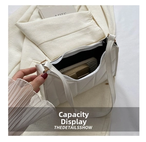 Interior view of white quilted underarm bag showing space for phone and wallet