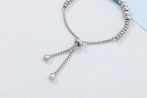 Detail of adjustable silver beaded box chain bracelet with sliding ring closure
