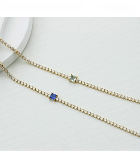 Detail of gold titanium steel bracelet with blue square stones and sparkling crystals
