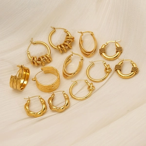 Minimalist gold-plated twisted and knotted hoop earring set on a beige textured cloth