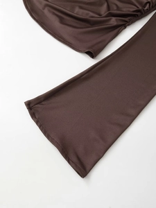Close-up detail of dark brown knit long-sleeve tee showing fine ribbed texture and fabric