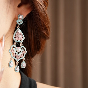 Gros plan de boucles d'oreilles vintage en forme de goutte avec turquoise et cristaux roses