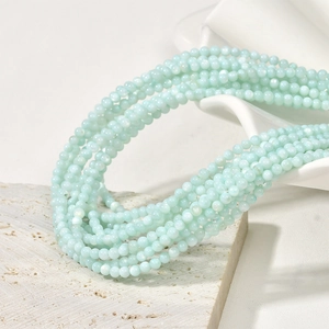 Detail of 3mm mint green natural shell beads on a layered necklace with soft luster
