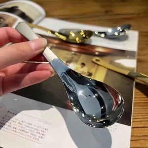 Close-up of a silver stainless steel round spoon held over an open magazine