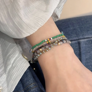Macro detail of multilayer crystal beaded bracelet in green and yellow bohemian style