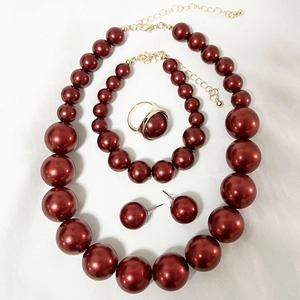 Detailed set of burgundy pearl jewelry including necklace, bracelet, ring and stud earrings