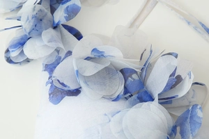 Gros plan sur des pétales en mousseline dégradé bleu et blanc avec une texture élégante
