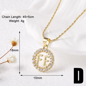 Macro shot of gold pendant necklace with cubic zirconia FE letters and cross details
