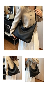 Détail du sac à bandoulière en cuir noir texturé avec un motif à rayures élégant