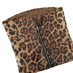 Détail de tissu à paillettes léopard avec fermeture éclair centrale en métal argenté