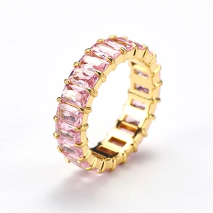Macro side view of rectangular pink zircon crystals on a polished gold eternity ring band