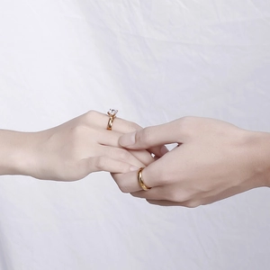 Paar goldene Edelstahl-Trauringe mit Zirkonia und poliertem Band im Set für Damen und Herren