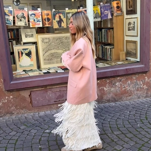 Blazer rosa casual da donna abbinato a una gonna lunga bianca con frange a strati
