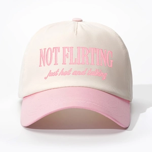 Detailed close-up of pink and beige baseball cap featuring Not Flirting embroidery