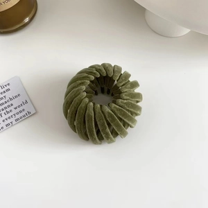 Detailed view of green velvet bird nest hair ring showing soft texture and elastic design