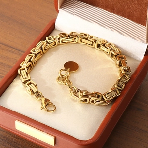 Elegant gold Byzantine chain bracelet in a leather gift box on a wooden table