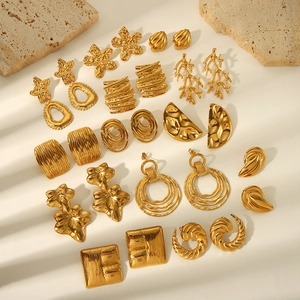 Vue de dessus de boucles d'oreilles irrégulières en acier doré aux finitions martelées