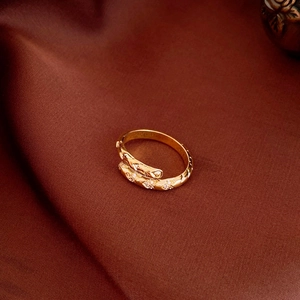 Gold-plated oval ring with twisted texture and shimmering cubic zirconia crystals
