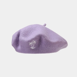 Detail of light purple wool beret with white coconut tree embroidery and textured fabric