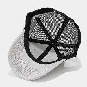 Detail of grey trucker hat showing breathable black mesh and adjustable snap closure