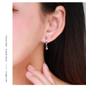 Close-up of S925 sterling silver hoop earrings with small round beads worn on ear