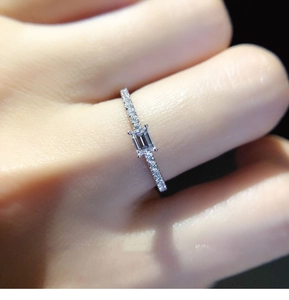 Detail of emerald cut square stone ring with micro pave setting on hand model