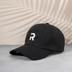 Close-up of premium black cotton baseball cap with white embroidered R letter detail