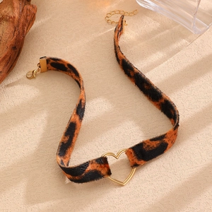 Dettaglio del choker leopardato con fibbia a cuore dorata e catenina di estensione