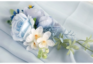 Macro shot of light blue rose and white floral corsage on elegant pleated chiffon fabric